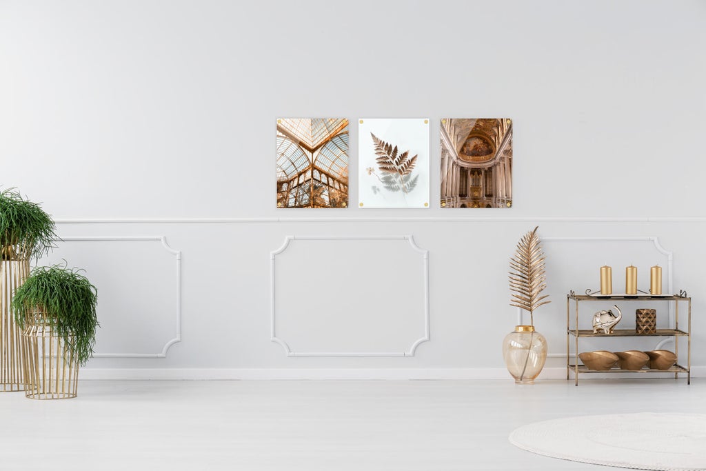 Three acrylic prints of gold-themed photos add rich luxury to an otherwise plain room.